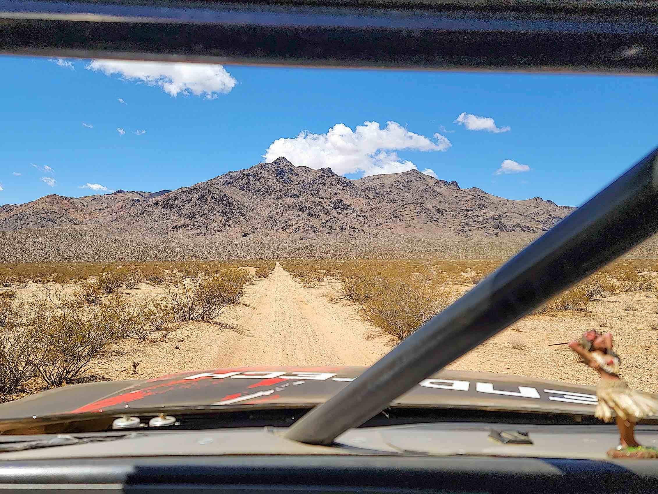 View of the desert from the cab of a racing truck.