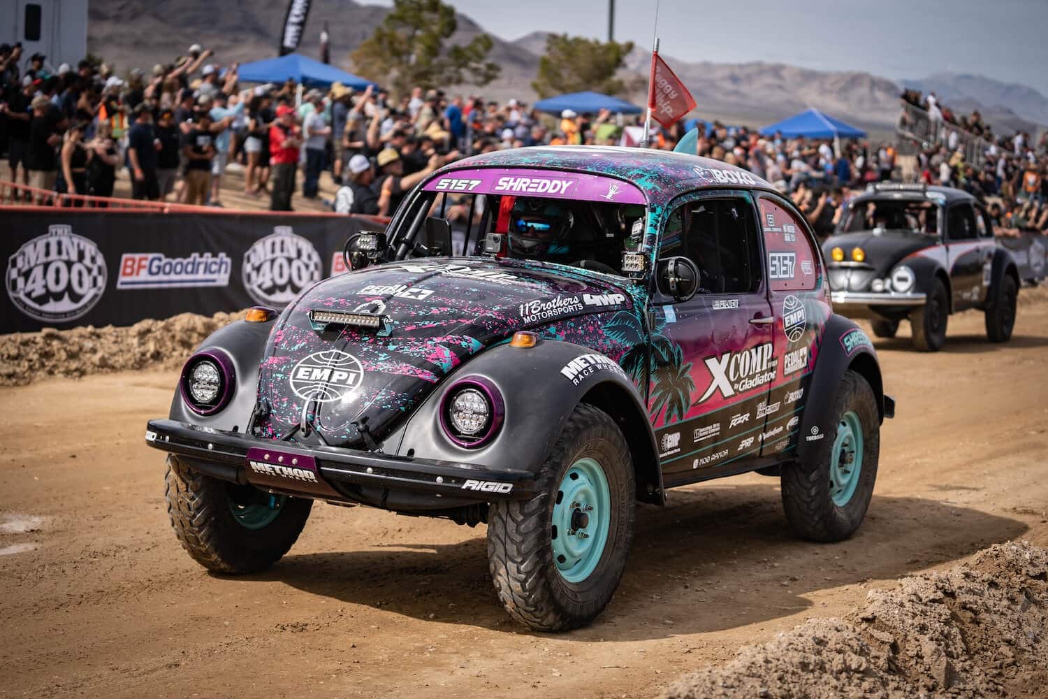 A VW Bettle racing on a dirt track.