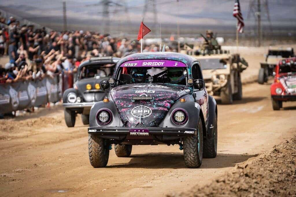 A VW Bettle racing on a dirt track.