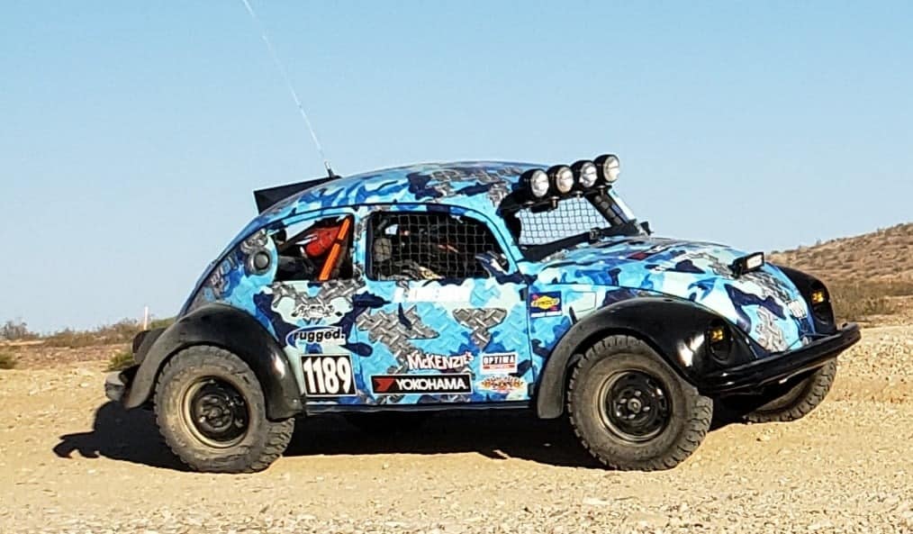 A VW Bettle on a dirt racing track.