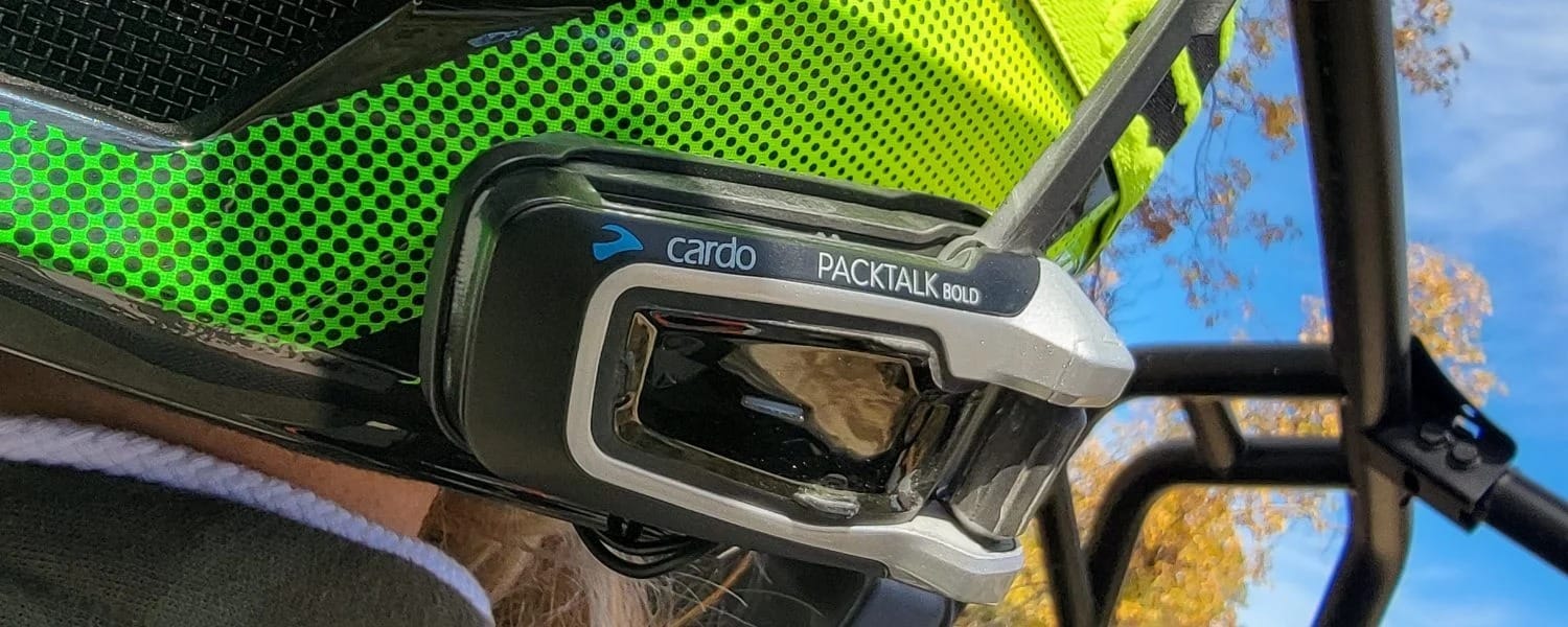 Cardo Systems Packtalk Bold on a green helmet.