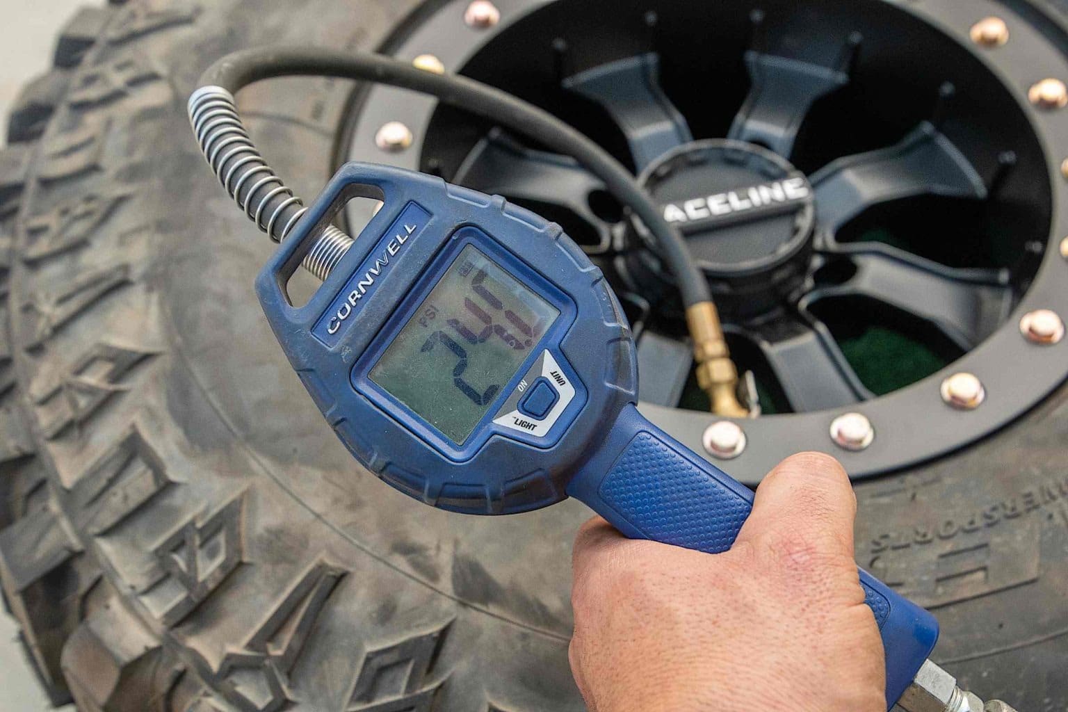 A tire pressure gauge measuring air in a tire.