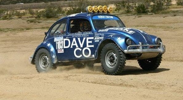 A VW Bettle racing on a dirt track.