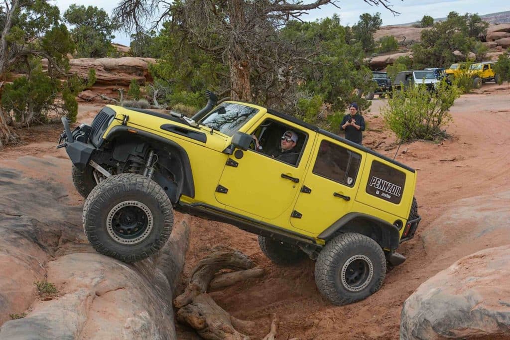 A yellow Jeep rides along an off-road track near the Grand Canyon.