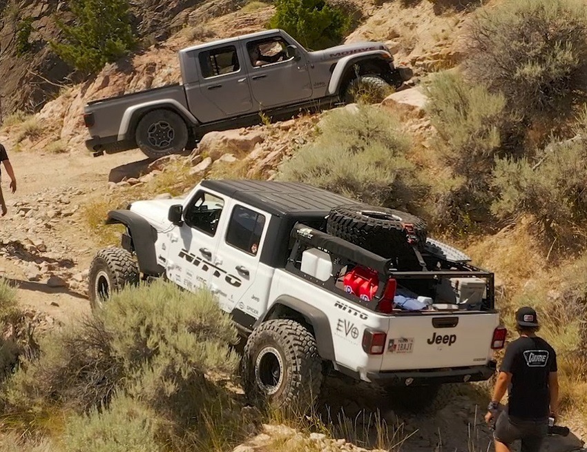 A white Jeep Gladiator driving up a hillside.