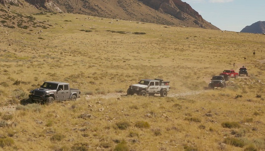 Several Jeep Gladiators driving over a dirt and rocky trail