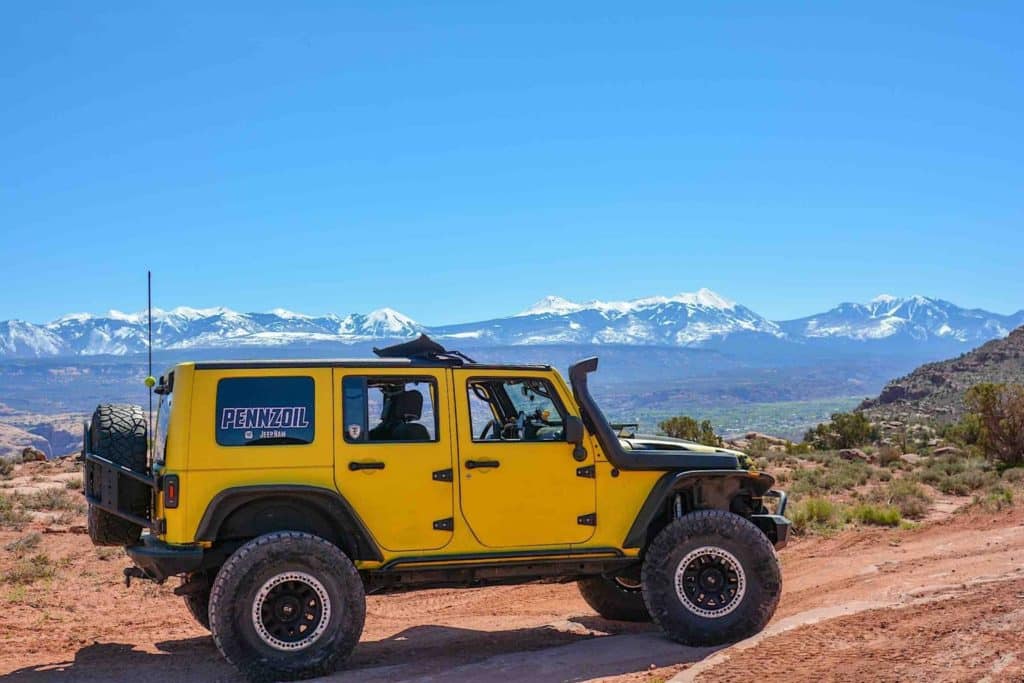 A yellow Jeep rides along an off-road track near the Grand Canyon.