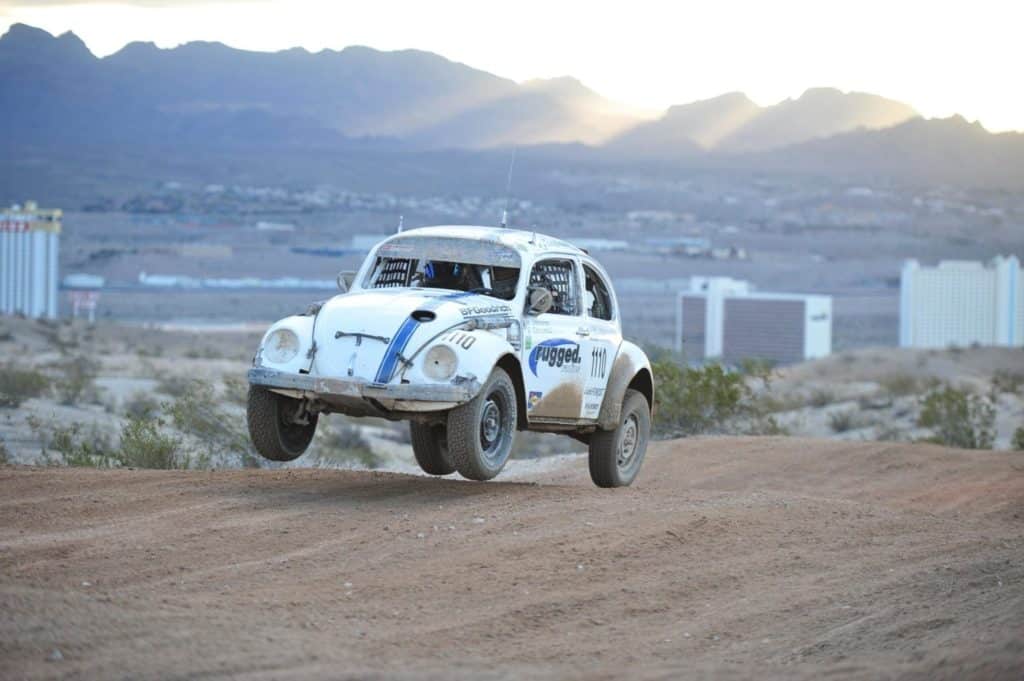 A VW Bettle racing on a dirt track.