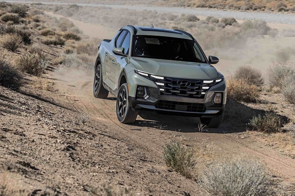 A Hyundai Santa Cruz driving through the desert.