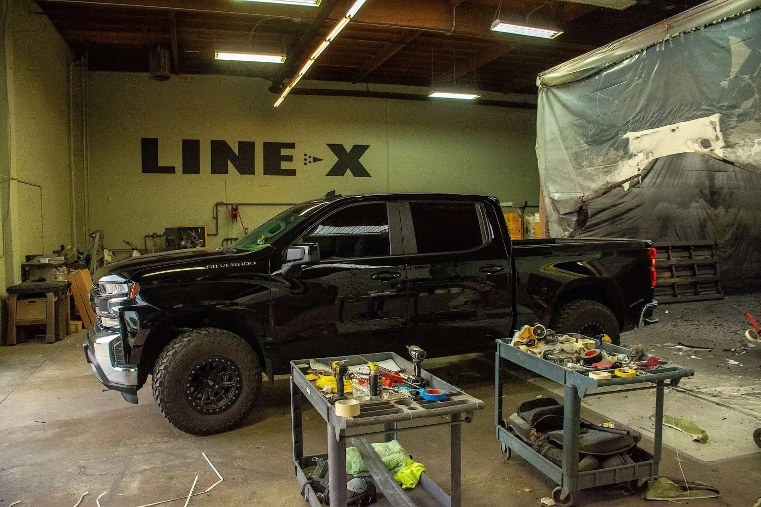 A black Chevrolet truck in a workshop.