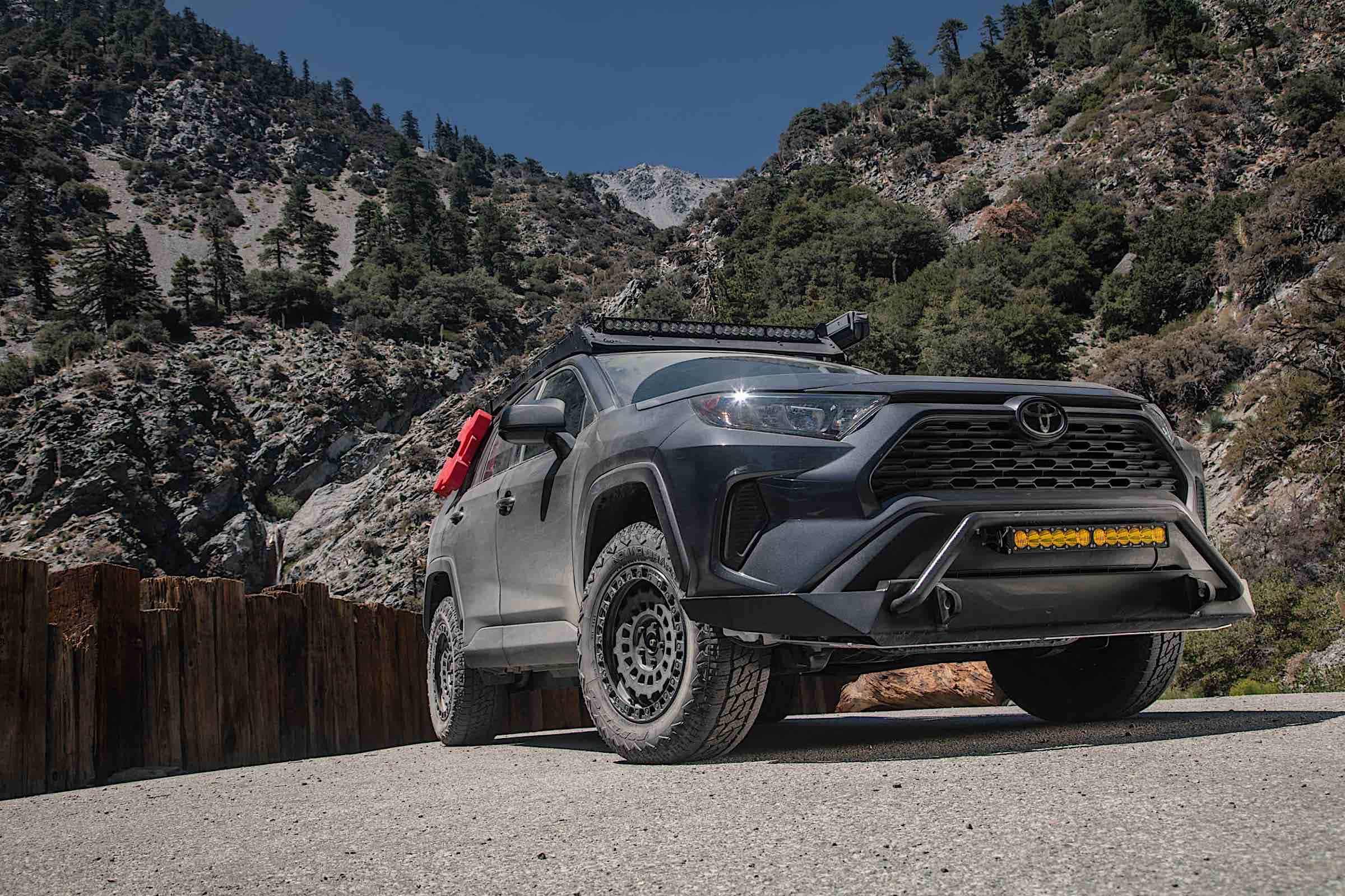 A sport utility vehicle fitted with Nitto Tires Nomad Grappler. Mountains and forests can be seen in the distance.