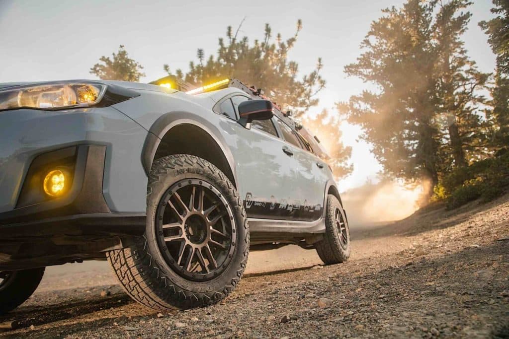 A sport utility vehicle fitted with Nitto Tires Nomad Grappler. Trees can be seen in the background with a setting sun.