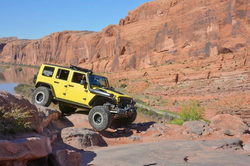 A yellow Jeep rides along an off-road track near the Grand Canyon.