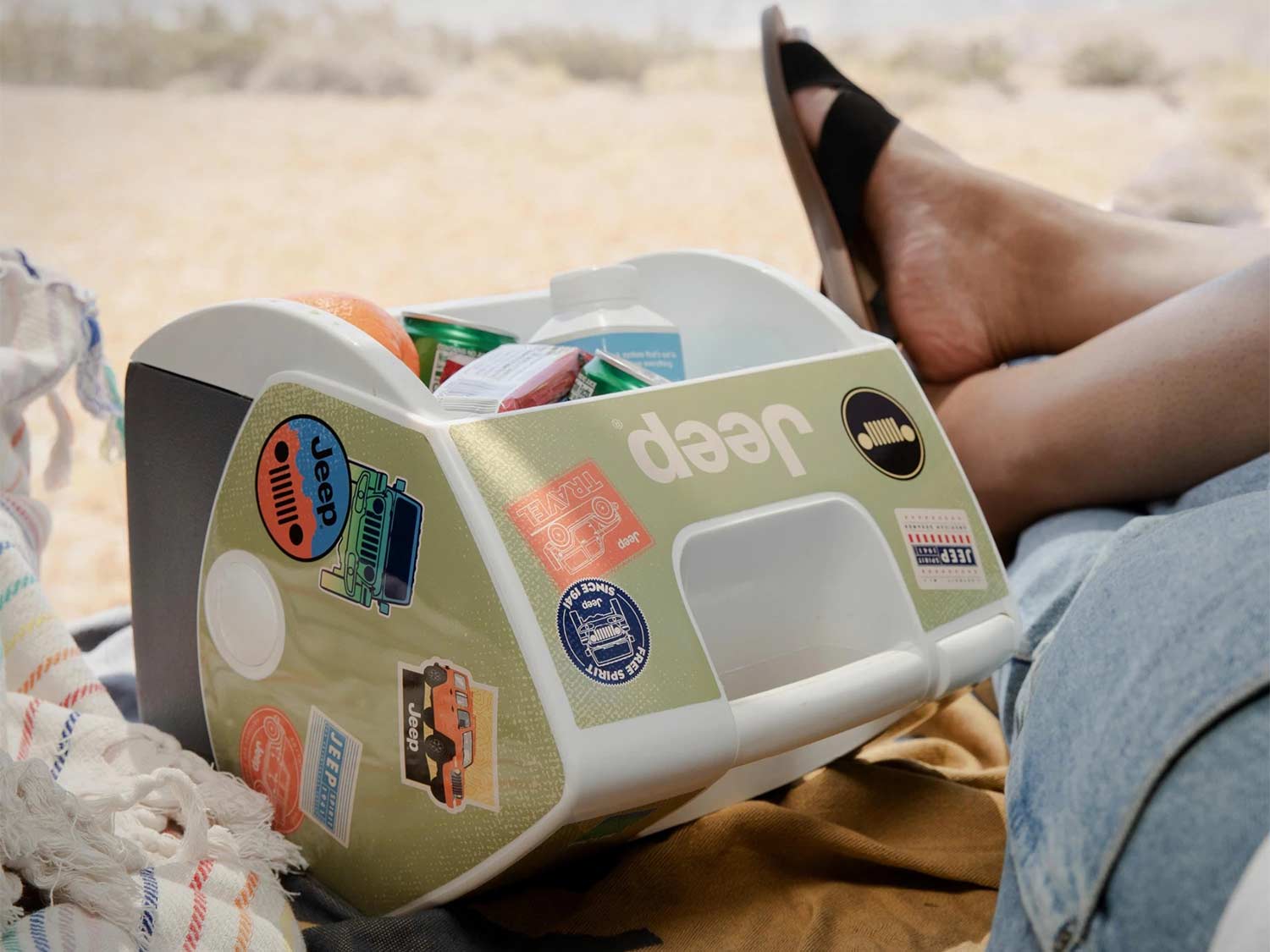 An Igloo Playmate cooler covered in Jeep stickers