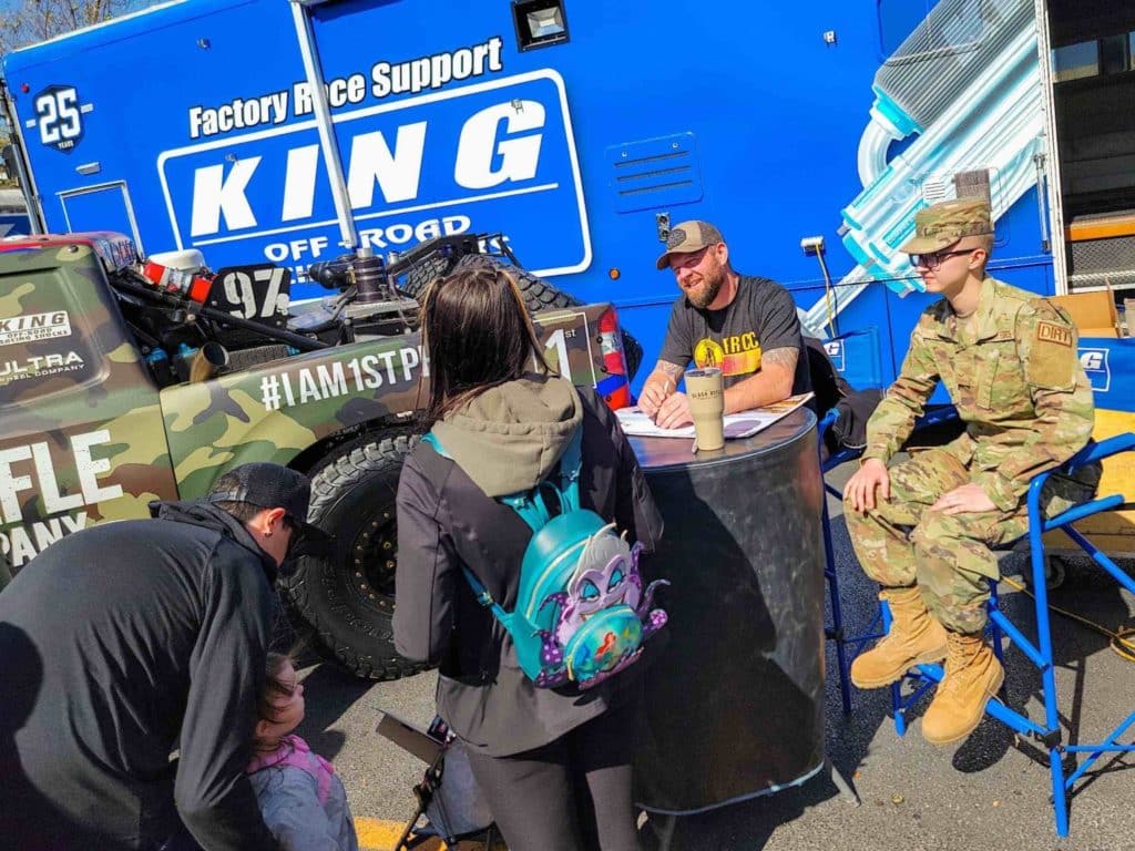 BJ Baldwin sitting at a table signing at the Mint 400 Off-Road festival