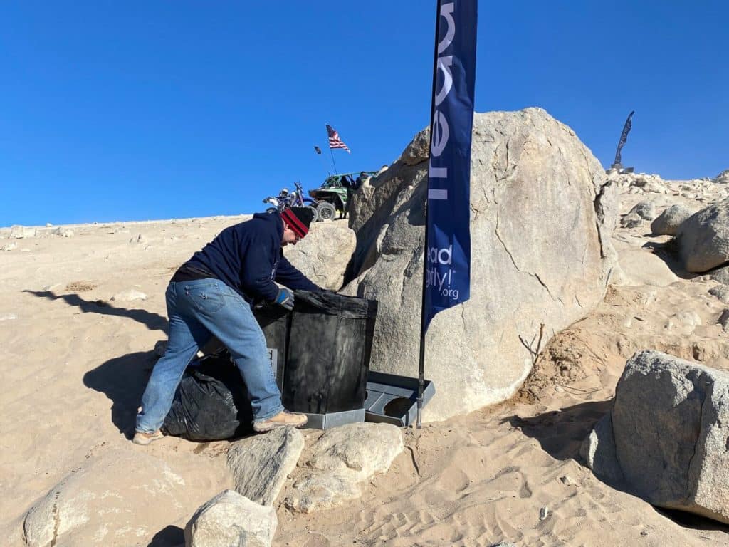 A crew cleaning up the desert after a race.