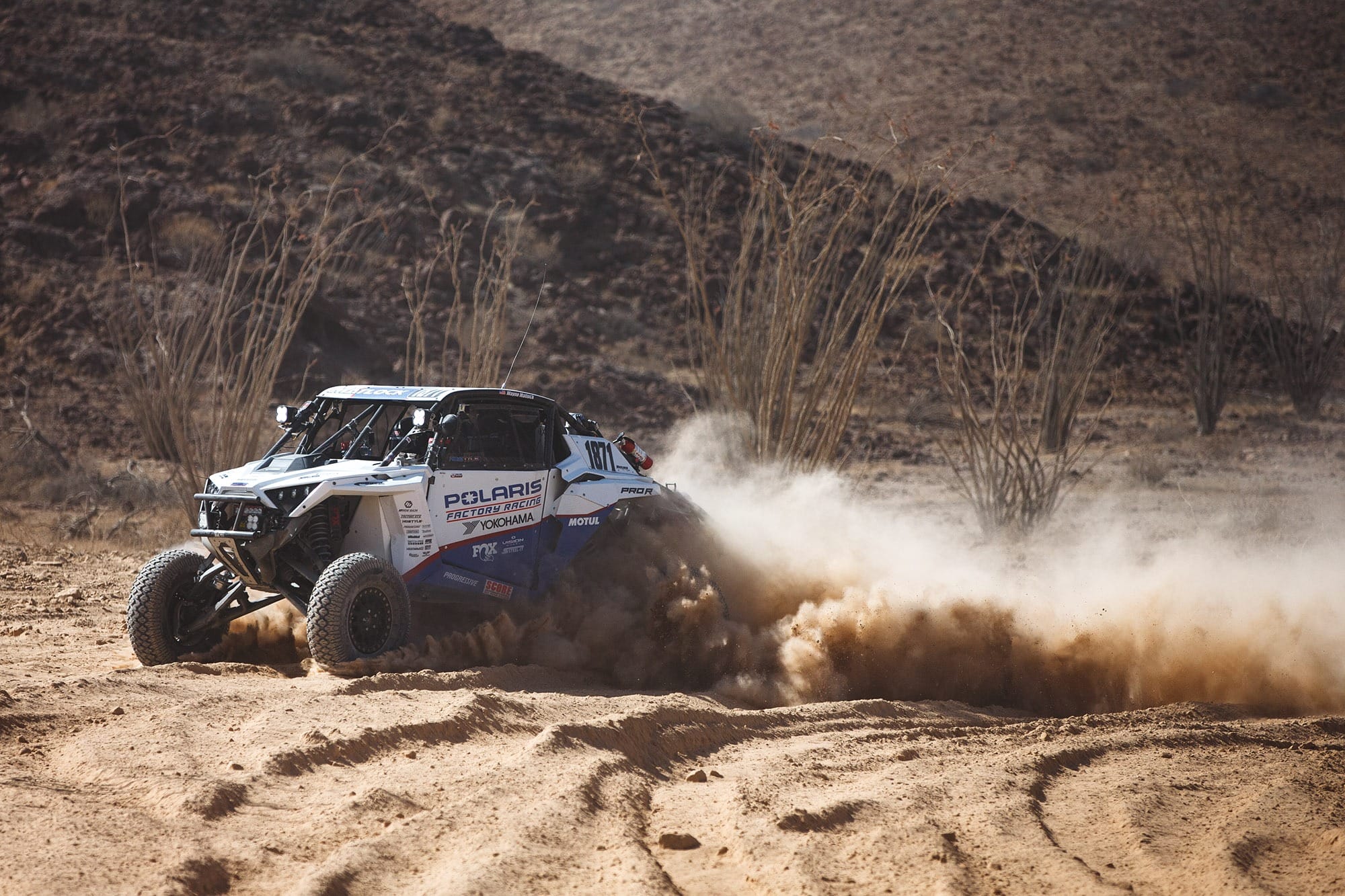 A sport-racing UTV on a dirt track.