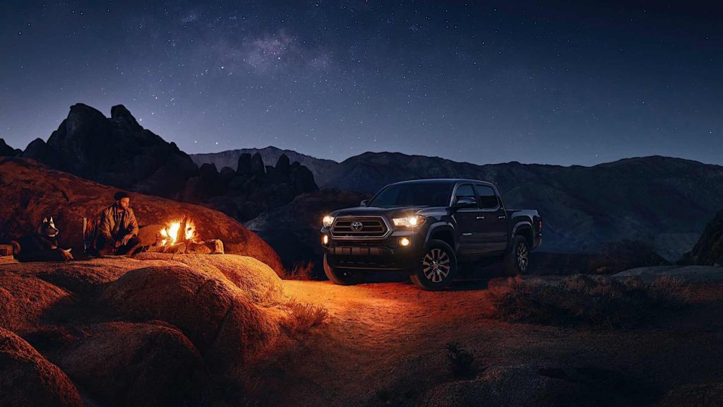 Red Toyota Tacoma SX Package at a camp at night.