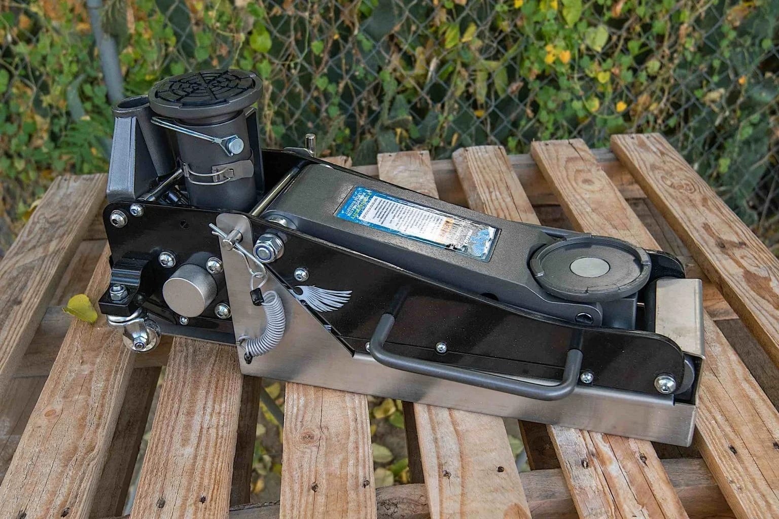 A tire jack on a wooden slat.