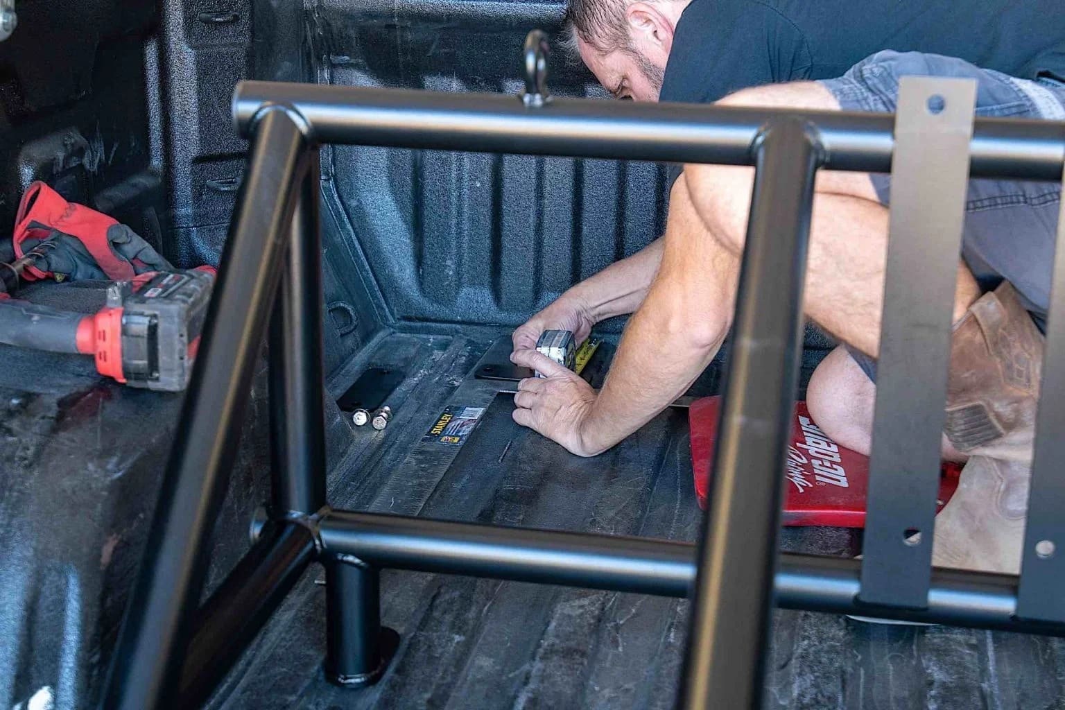 Installing a tire rack into a truck bed.