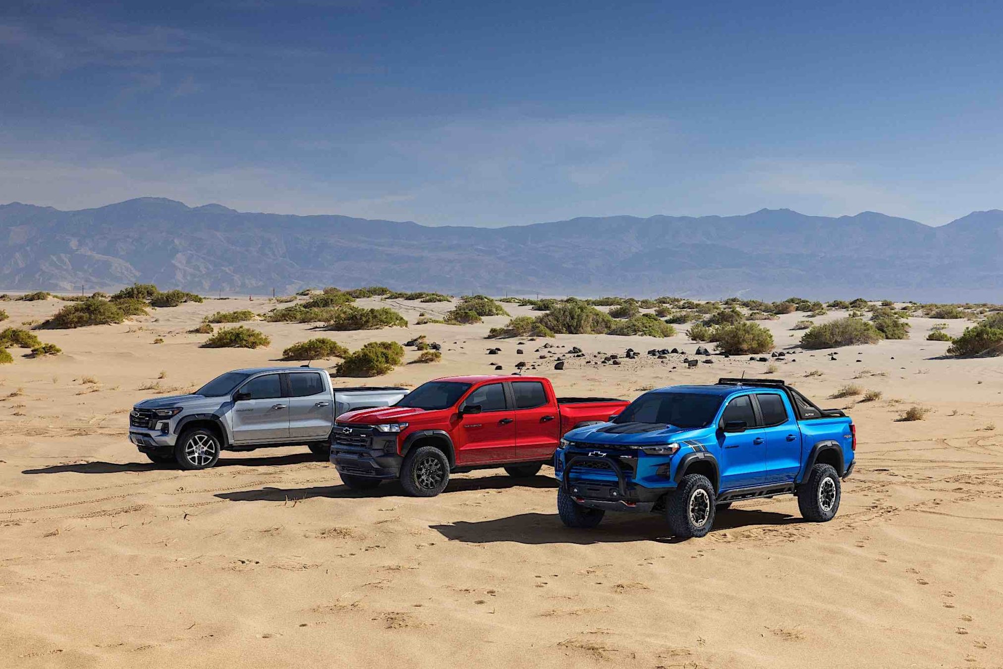 Three 2023 Chevrolet Colorado parked in the desert.