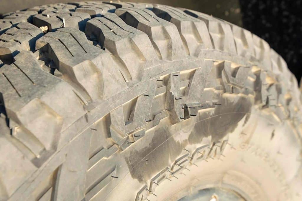 Deep tire tread of a dirt-covered Mickey Thompson Baja Boss A/T Tire