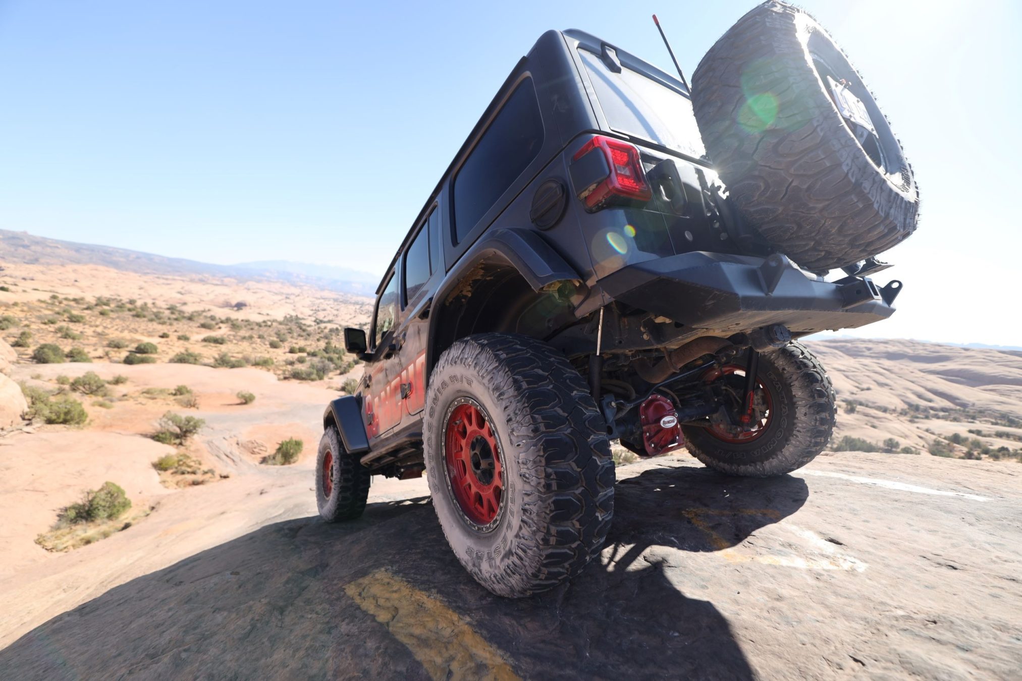 A jeep driving over rocky and dirt terrain.