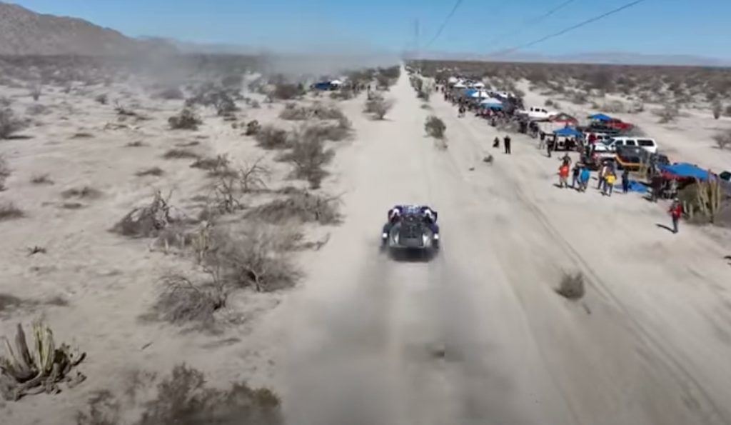 A trophy truck riding through a desert trail