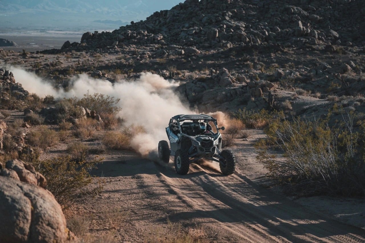 A Can-Am driving through the desert.